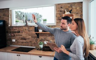 Couple talking about home renovation. Standing in the kitchen and discussing apartment renovation ideas.