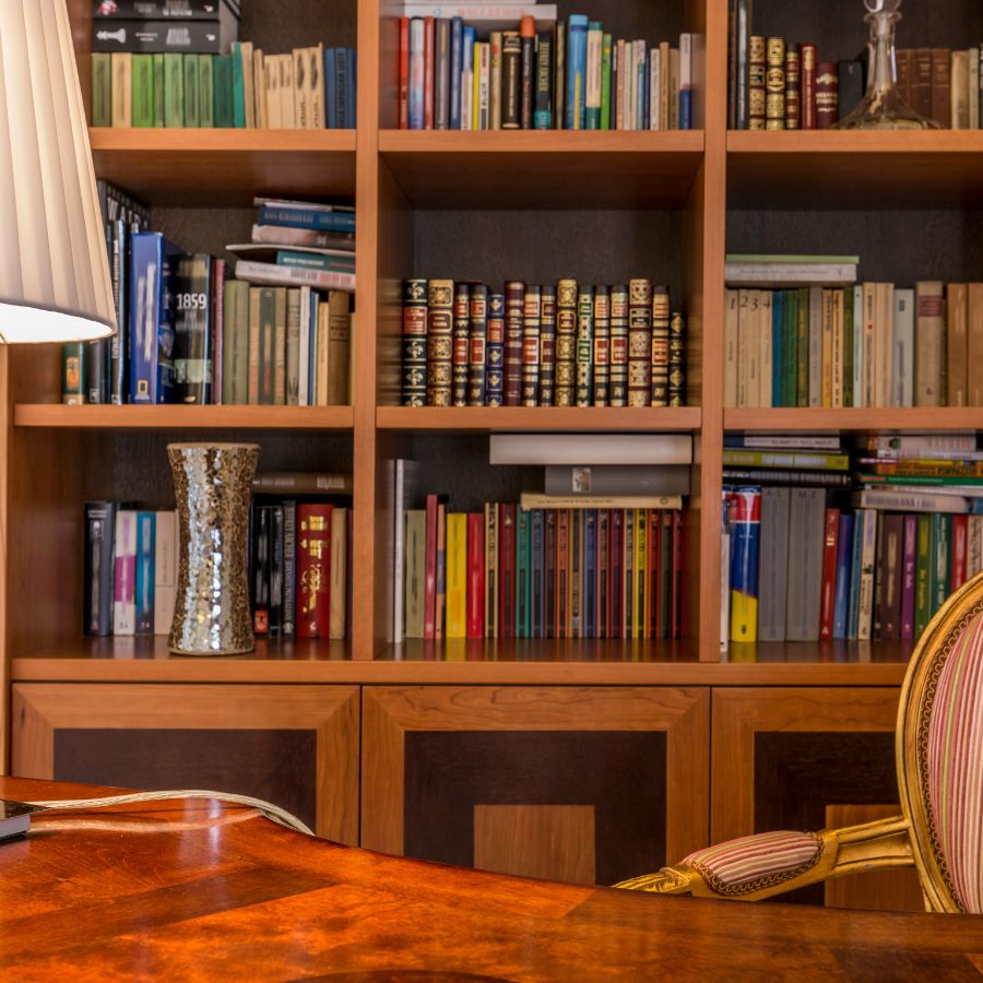 Built in bookcase filled with books behind a desk