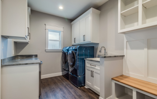 white mudroom cabinets with black washer and dryer