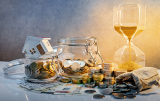 change jar with coins alongside an hourglass