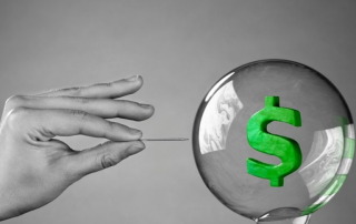 hand bursting a bubble with a dollar symbol inside