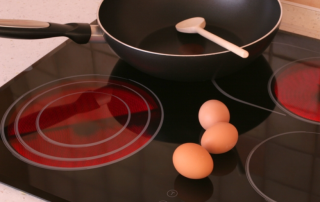 a saucepan and three eggs on an electric stovetop