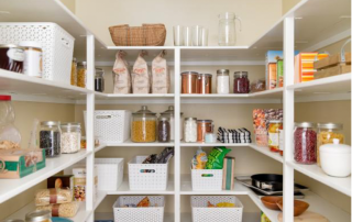 organized and well-stocked walk-in pantry with white organizer baskets and shelves