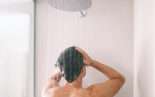 Back view of a man in a glass shower