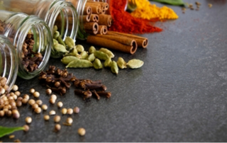 open spice jars arranged to reveal their contents onto a clean, grey countertop