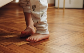 small child's feet on a wooden parquet floor